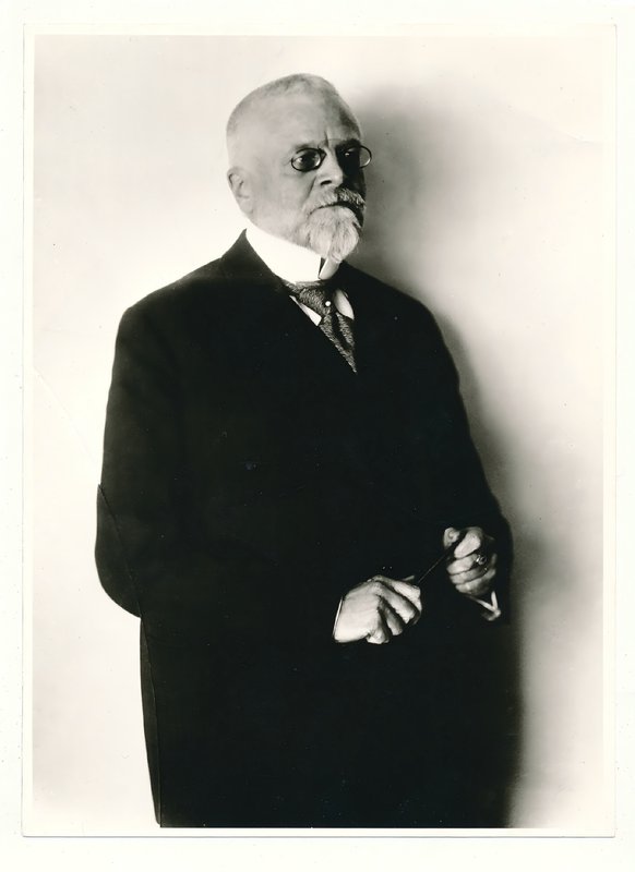 Schwarzweiß-Porträt von Fritz Schumacher mit weißem Bart und Brille im dunklen Anzug