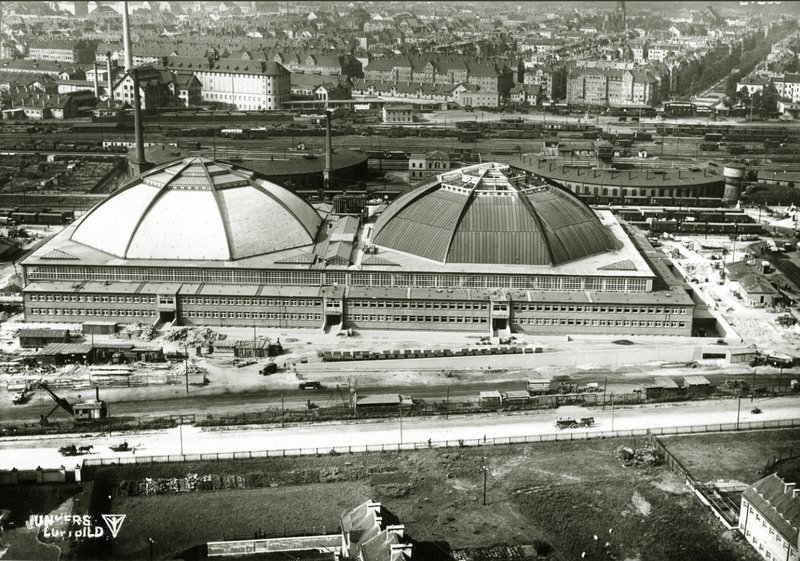 Luftbild der Großmarkthalle mit zwei großen Kuppeln, Gleisanlagen und Stadt im Hintergrund