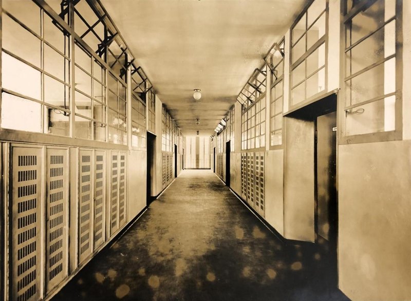 Historisches Foto: langer Schulflur mit Fensterreihen zu den Klassenzimmern und Lüftungsschränken darunter
