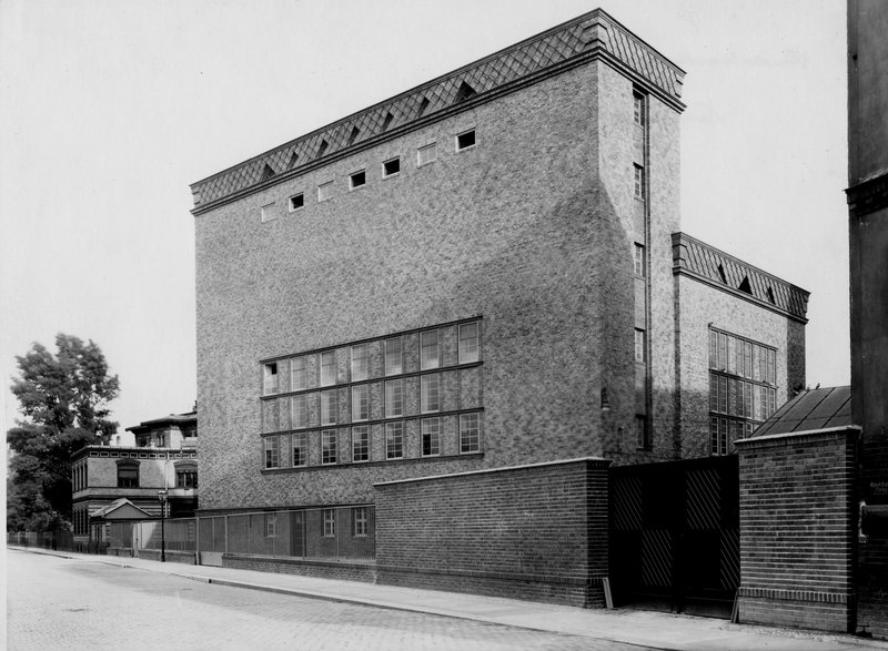 Hoher kubischer Klinkerbau mit kleinen Fensterreihen und Schornsteinaufsatz; Schwarz-Weiß-Fotografie